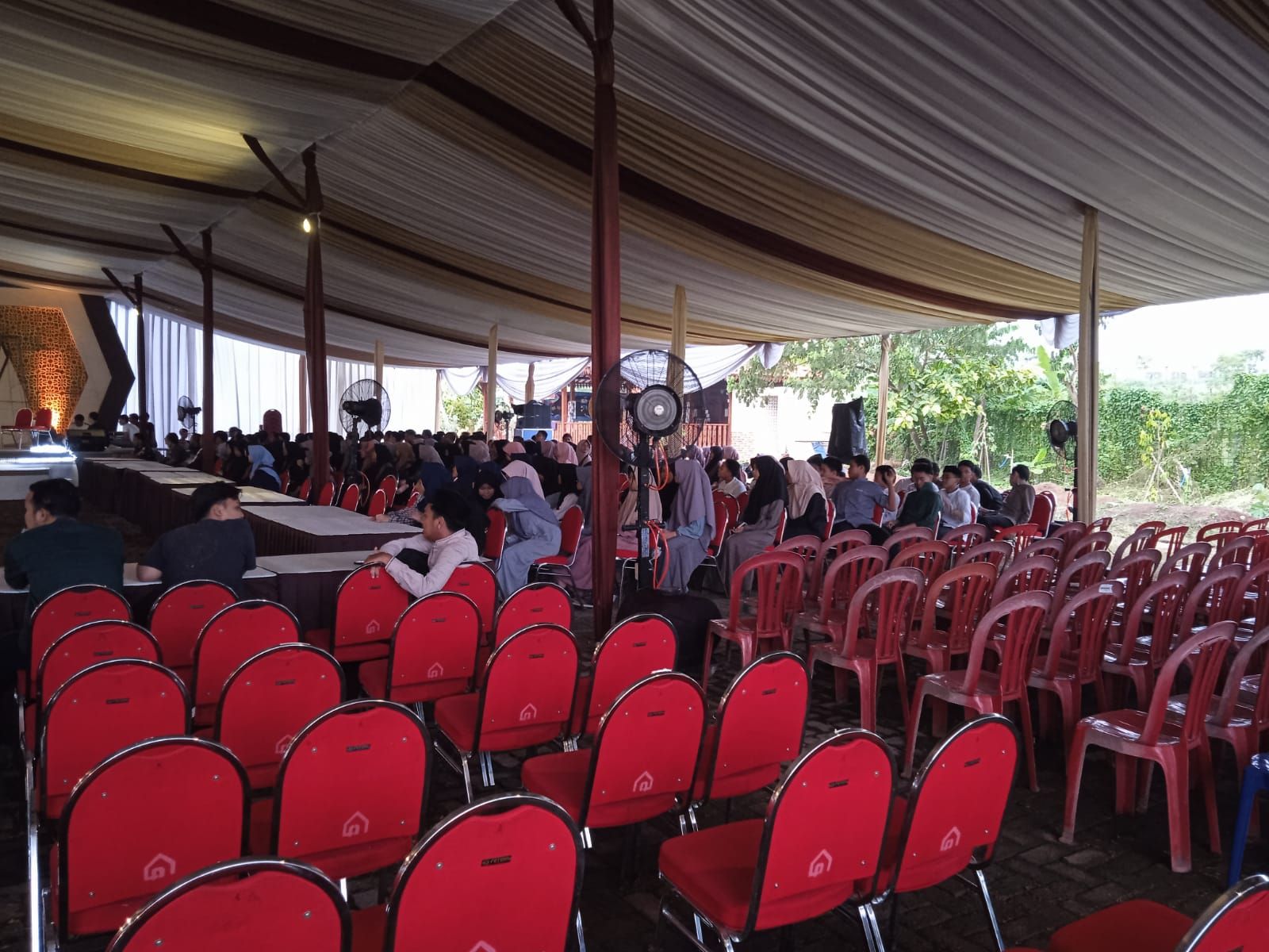 Suasana tenda acara outdoor yang nyaman dan sejuk berkat penggunaan kipas angin air (misty fan) untuk mengatasi cuaca panas di siang hari